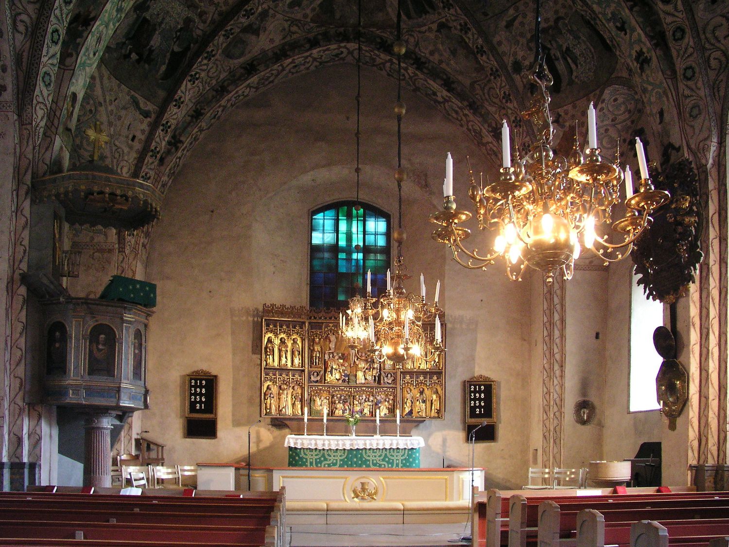 the nave of täby church from the pews: the pulpit on the left, the altarpiece, the painted vaults above
